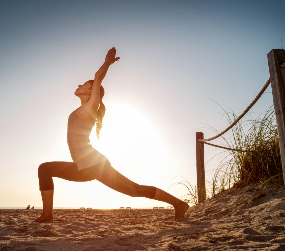 Woman practicing yoga on sandy beach